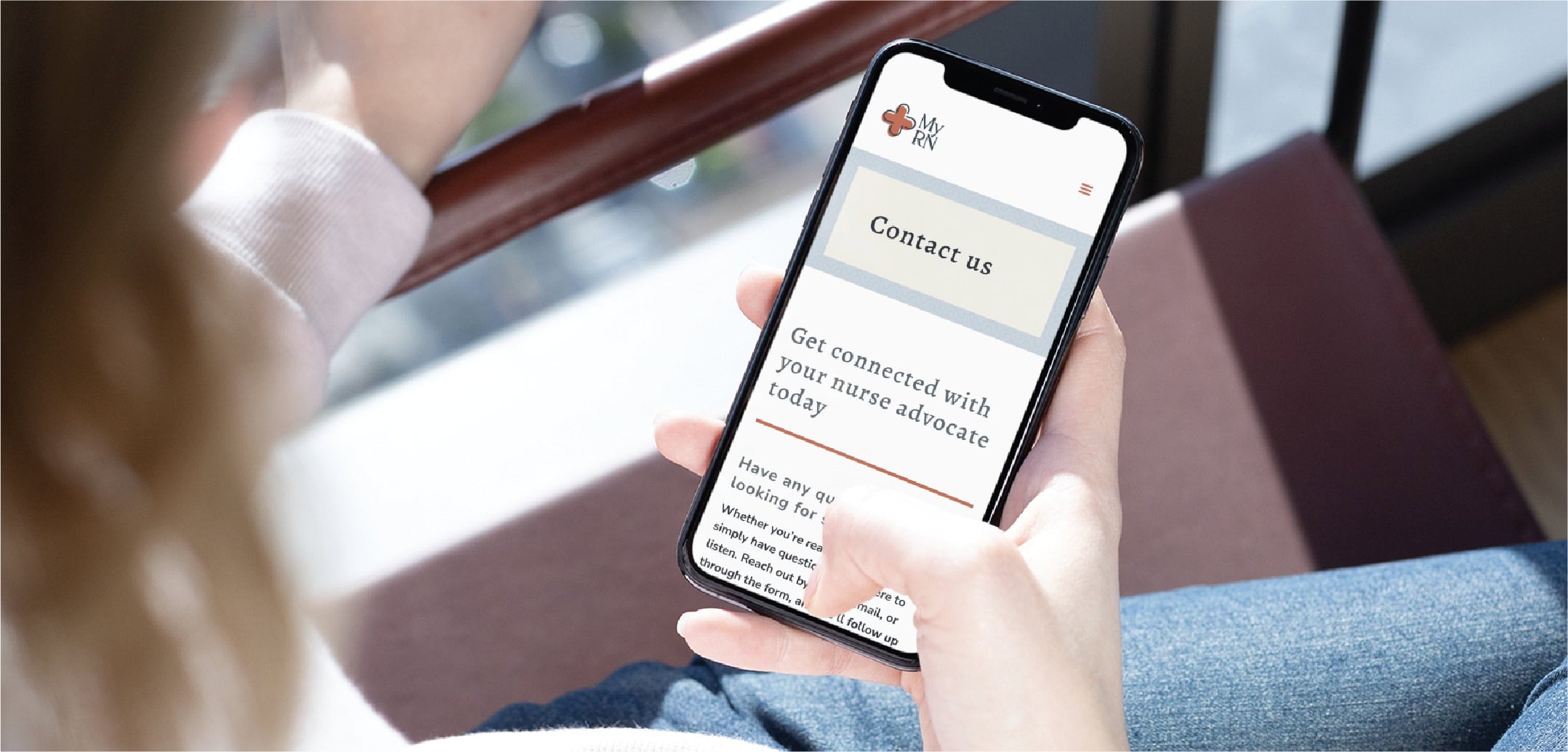 A person holds a smartphone displaying a beautifully crafted website with a Contact us section and a message about connecting with a nurse advocate, highlighting exceptional RN Services available in Minnesota.