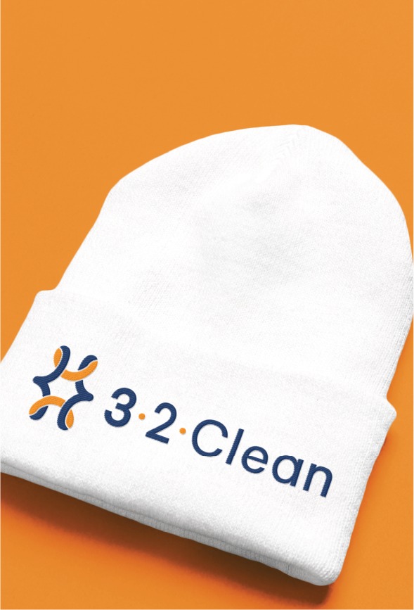 A white beanie hat with a blue and orange abstract logo and the text 3•2•Clean on the front, placed on an orange background—perfect for fans of Tulane University or anyone seeking New Orleans-inspired style for their next website design shoot.