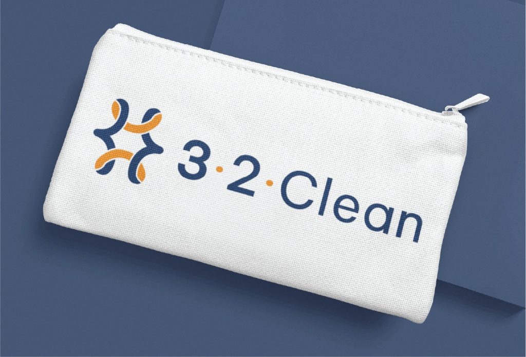 A white zippered pouch on a blue background displays a blue and orange logo next to the text 3·2·Clean in blue letters, reminiscent of the vibrant design often associated with Tulane University in New Orleans.