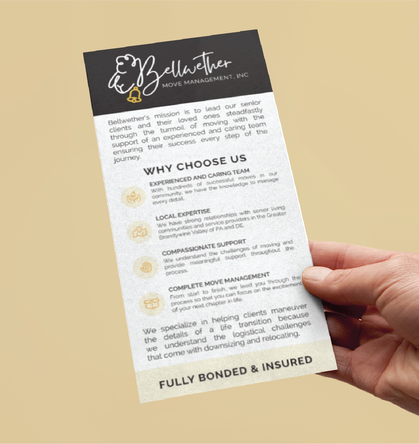 A hand holds a Bellwether Move Management flyer showcasing expert print design, listing moving services, benefits like experience, support, and being fully bonded and insured. The flyer features a black header with a logo and organized text below, ideal for those relocating in California or involved in nonprofit housing projects.