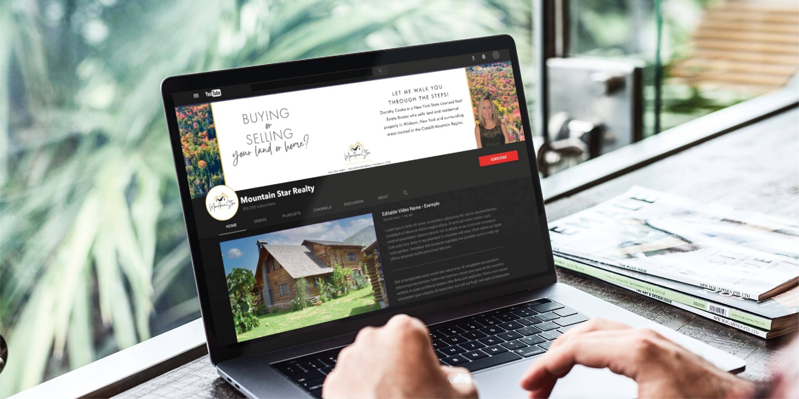 Person using a laptop displaying a YouTube channel for Mountain Star Realty, featuring a log cabin video, banner with text about buying and selling homes in Michigan, and contact info—all showcasing the company’s custom social media design—set on a bright desk near a window.