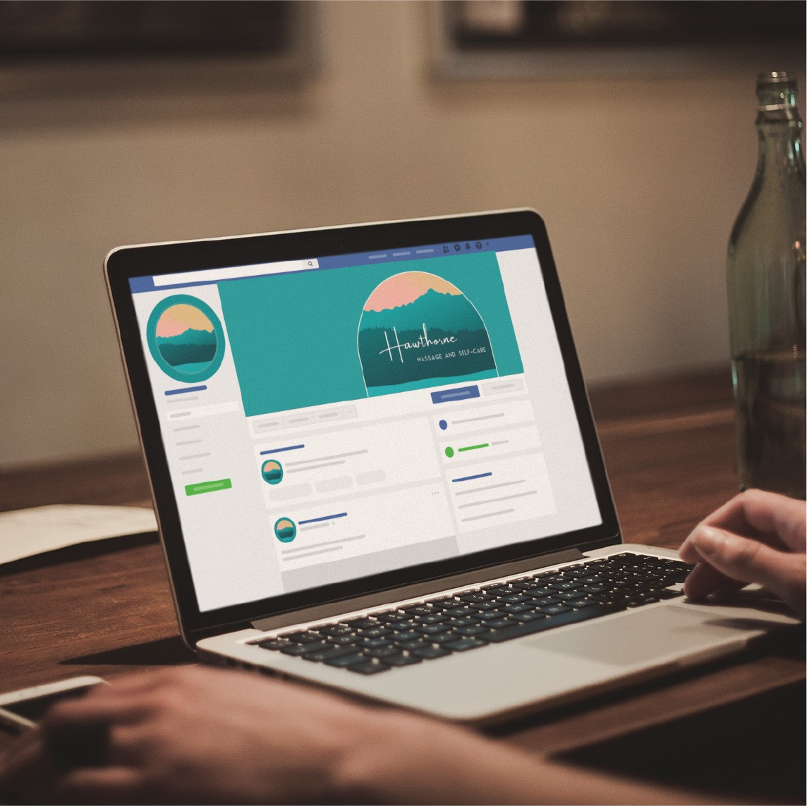 A person uses a laptop displaying a social media page for Hawthorne Wellness and Self-Care, a Pennsylvania skincare brand, featuring a green and peach logo with a mountain and sun design that highlights thoughtful social media design.