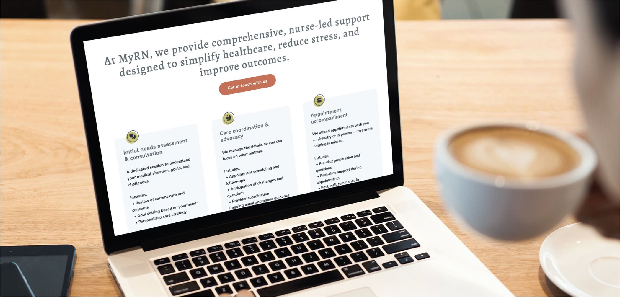 A person holding a cup of coffee sits at a table while viewing a laptop displaying a Minnesota healthcare website with thoughtful website design, describing RN services, nurse-led support, and steps for care coordination.