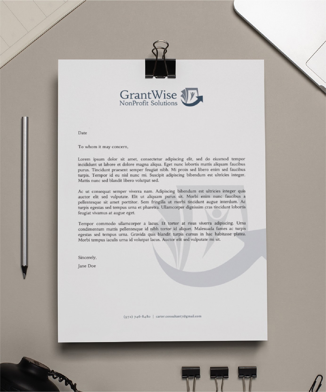 A letterhead on a clipboard with the GrantWise NonProfit Solutions logo, pen, glasses, phone, and paper clips arranged neatly on a beige desk. Showcasing professional print design, the letter starts with To whom it may concern...—perfect for organizations in Pennsylvania seeking polished communication materials.