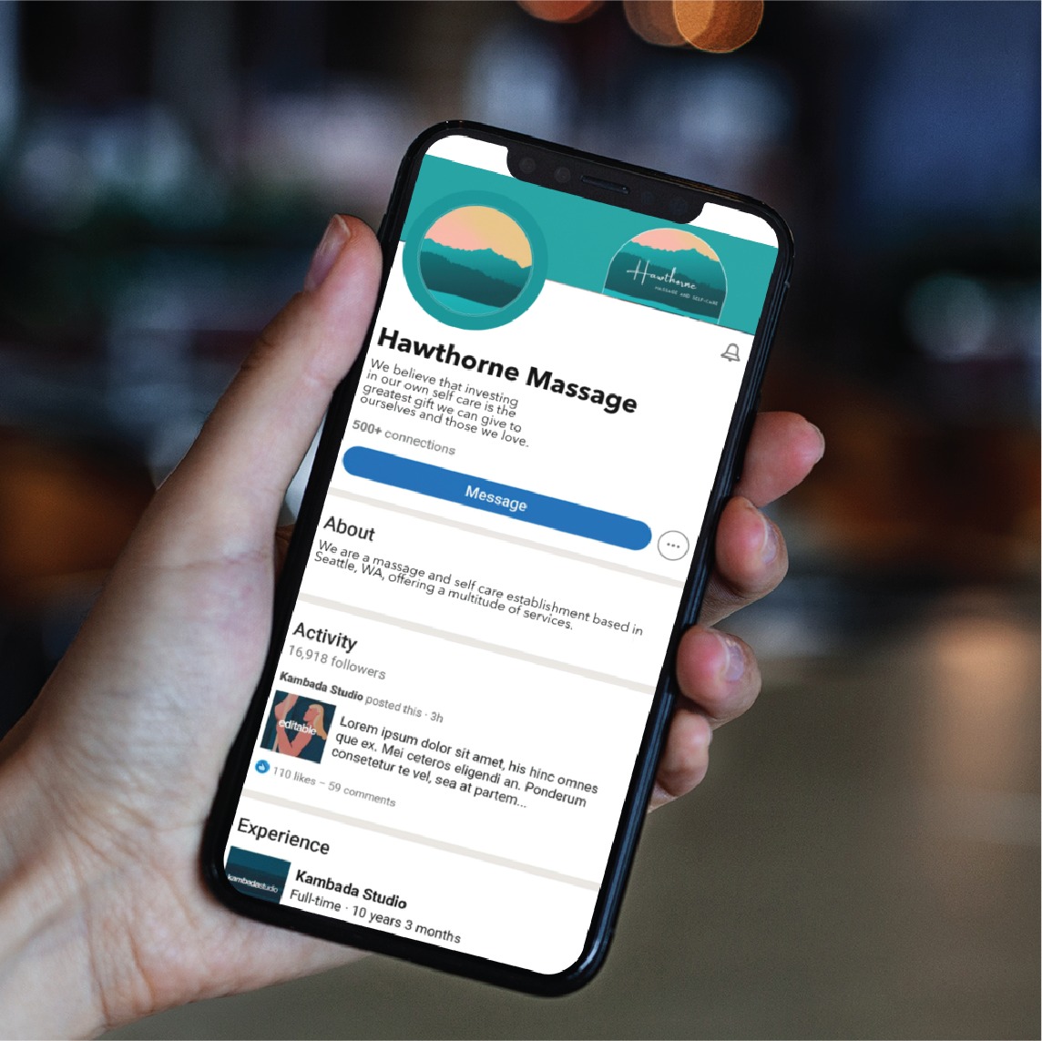 A person holds a smartphone displaying a business profile for Hawthorne Massage, featuring the logo, about section, activities, and experiences—all enhanced by custom social media design elements. The phone is in the left hand against a blurred indoor background, highlighting the professionalism of this premier Masseuse Washington business.