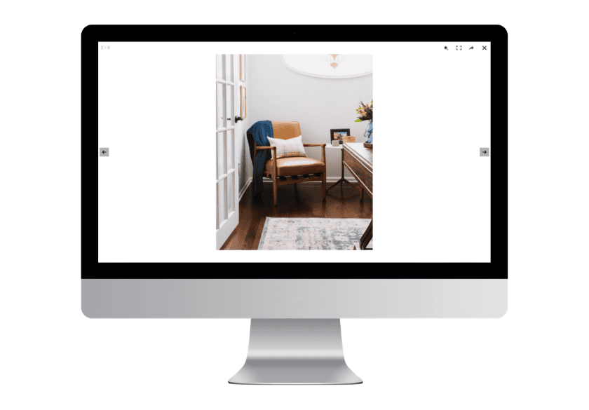 A leather armchair with a blue throw blanket and a decorative pillow displayed on a computer monitor for website gallery tips.