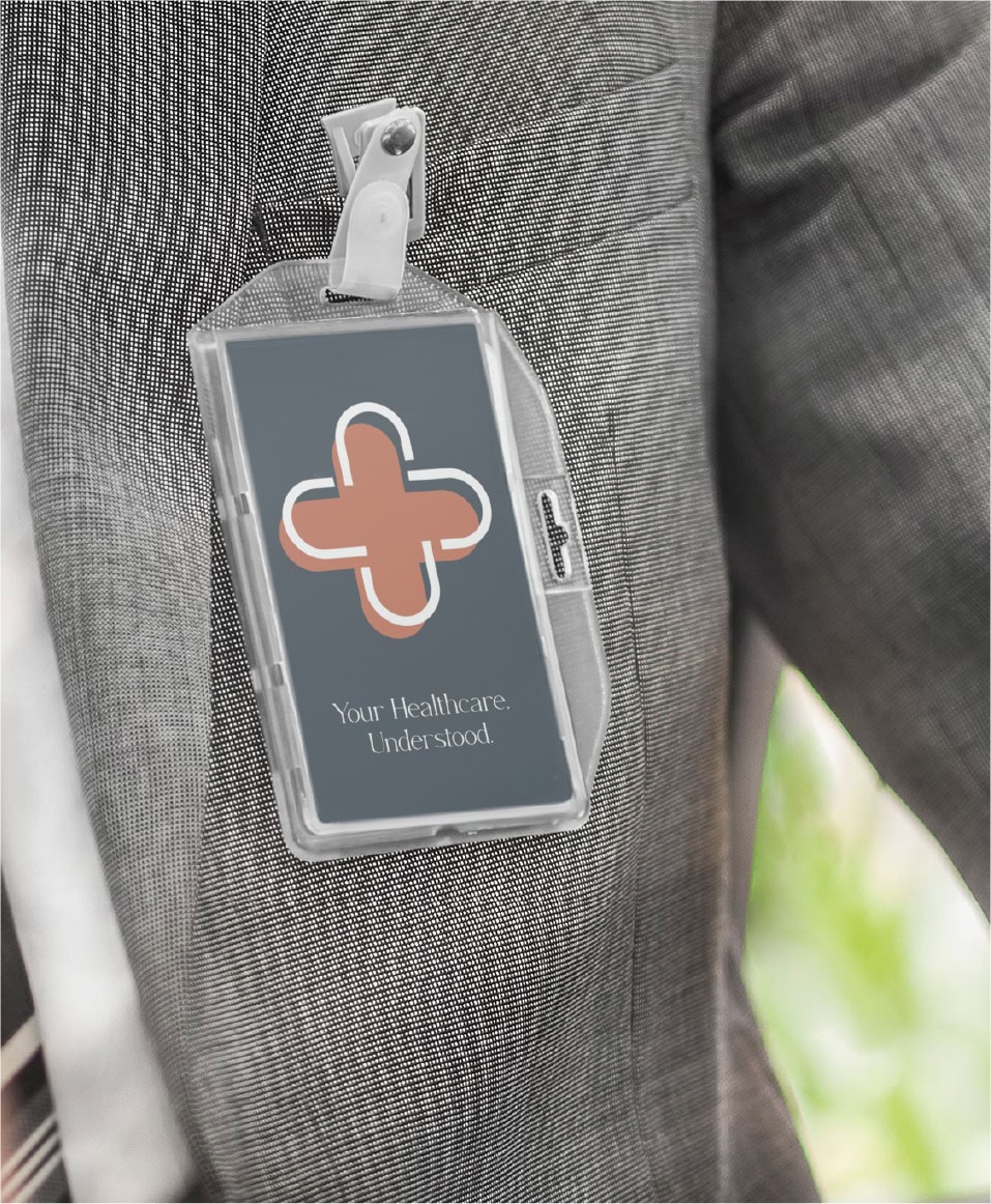 An ID badge with a stylized medical cross logo and the text, Your Healthcare. Understood., clipped to a grey blazer, shown in a custom stationery design.