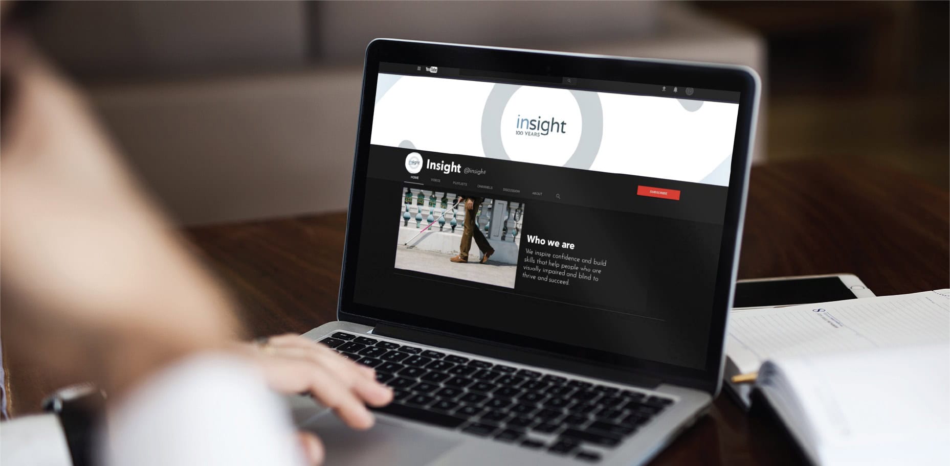A laptop screen displaying the Insight YouTube channel, showcasing nonprofit marketing materials that highlight their mission to support visually impaired and blind individuals.