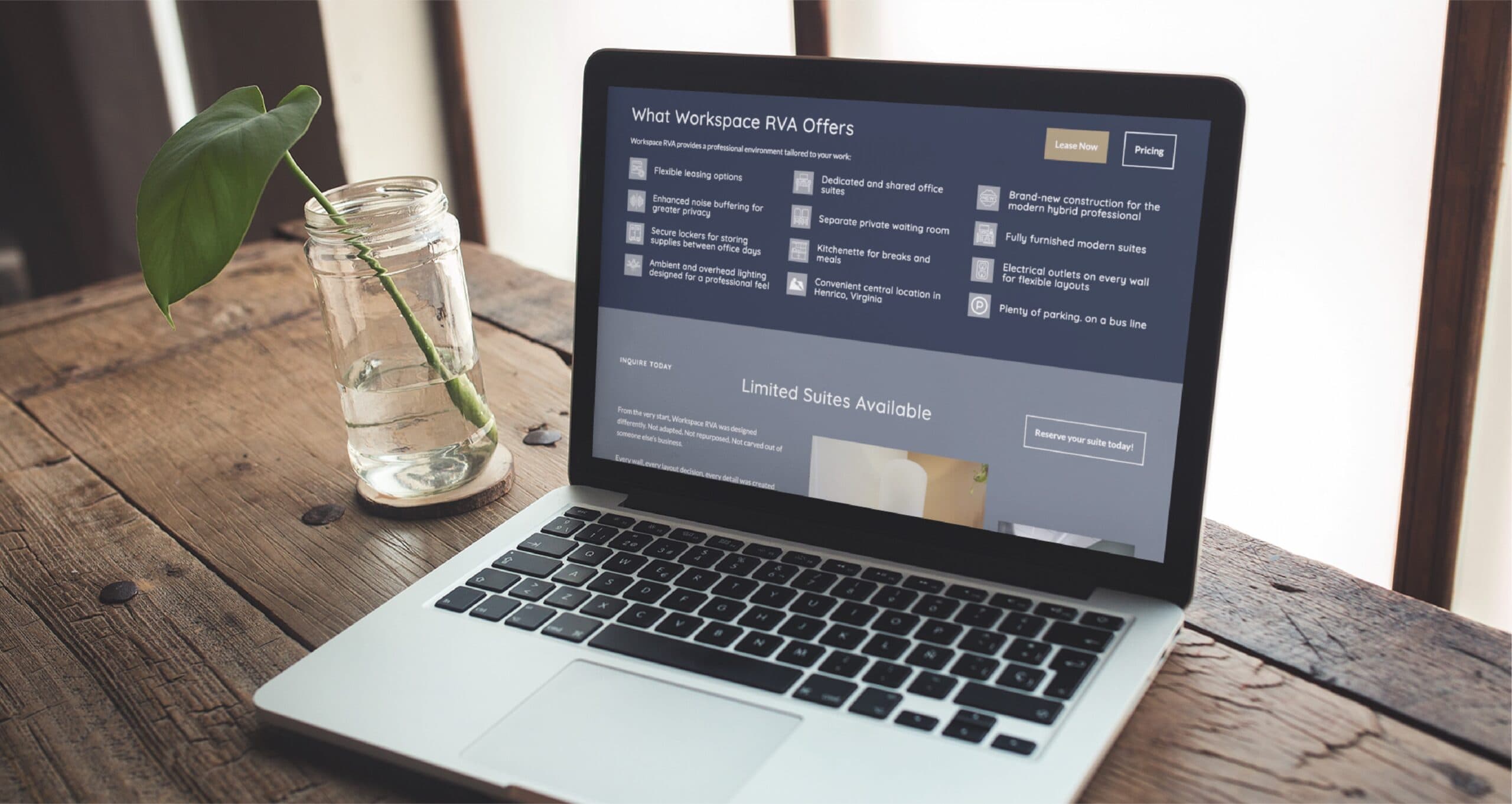 A laptop on a wooden table displays a website design workspace offers webpage. Next to it is a mason jar with water and a leafy green plant. Sunlight illuminates the scene.