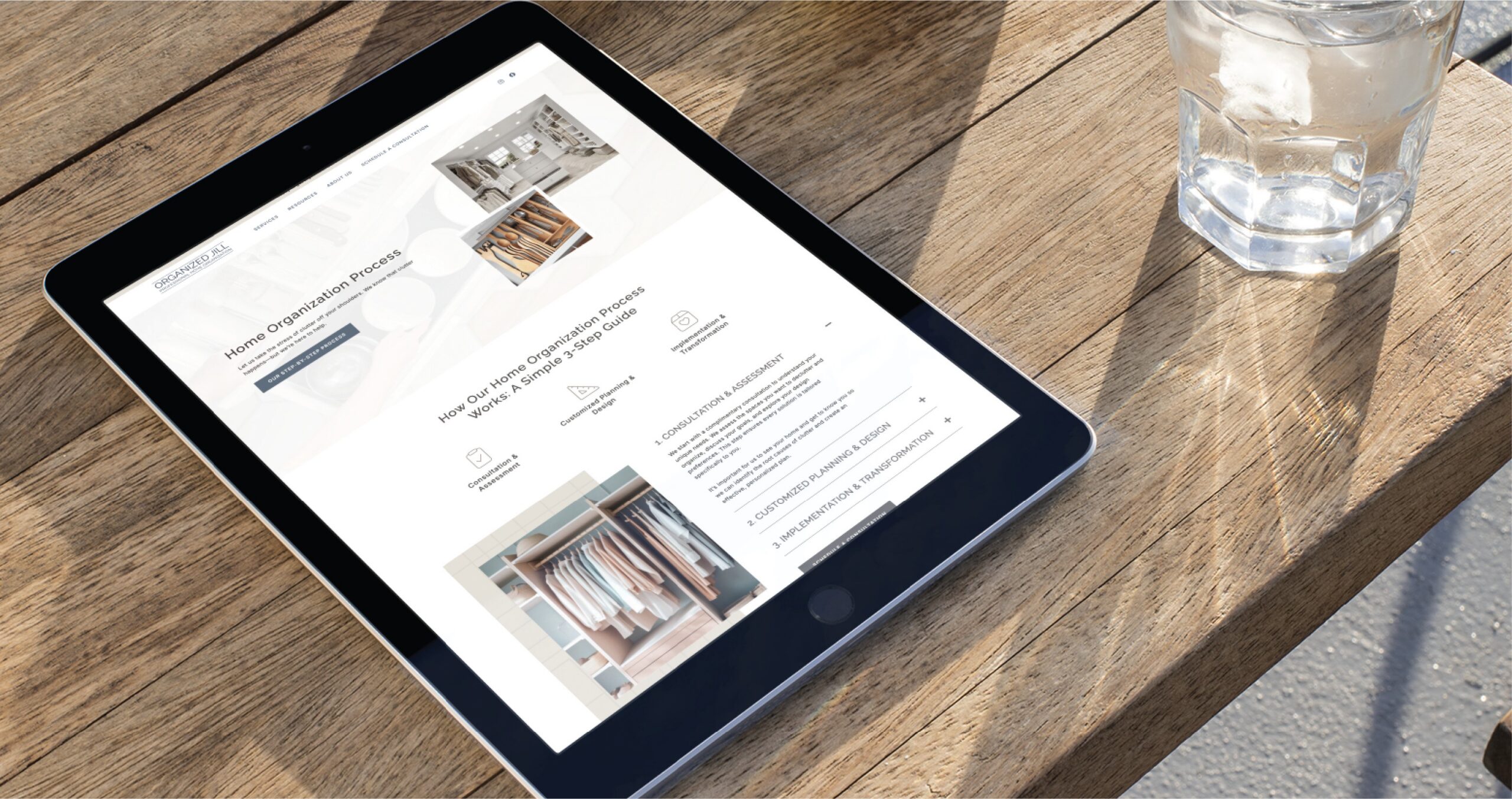 A tablet on a wooden table displaying the Organized Jill website, which showcases professional organizer website design with a three-step home organization guide.
