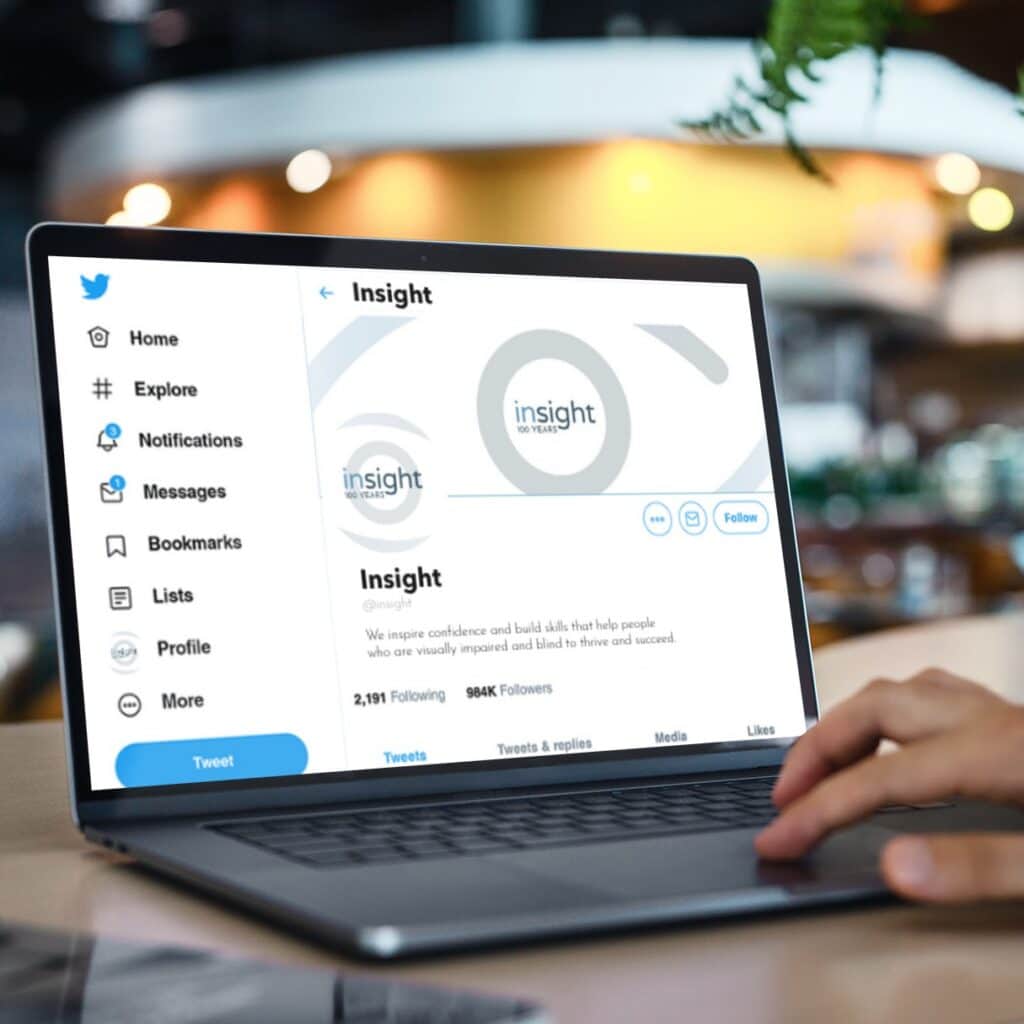 A person using a laptop to view the social media design of a Rhode Island nonprofit’s Twitter profile page for an organization called Insight.
